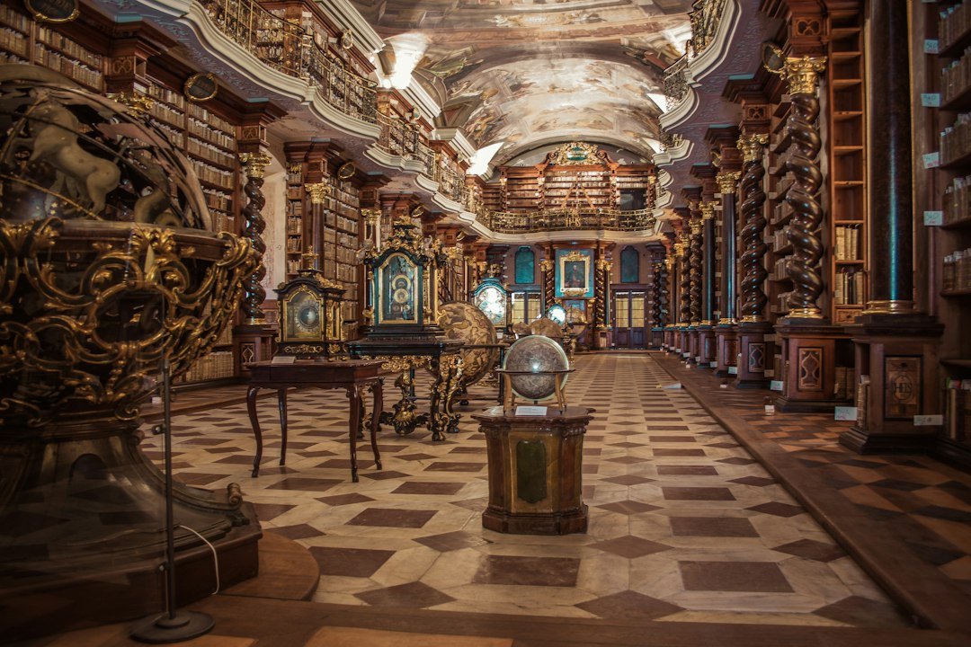 A grand historic library with painted ceilings, globes and towering wooden bookshelves